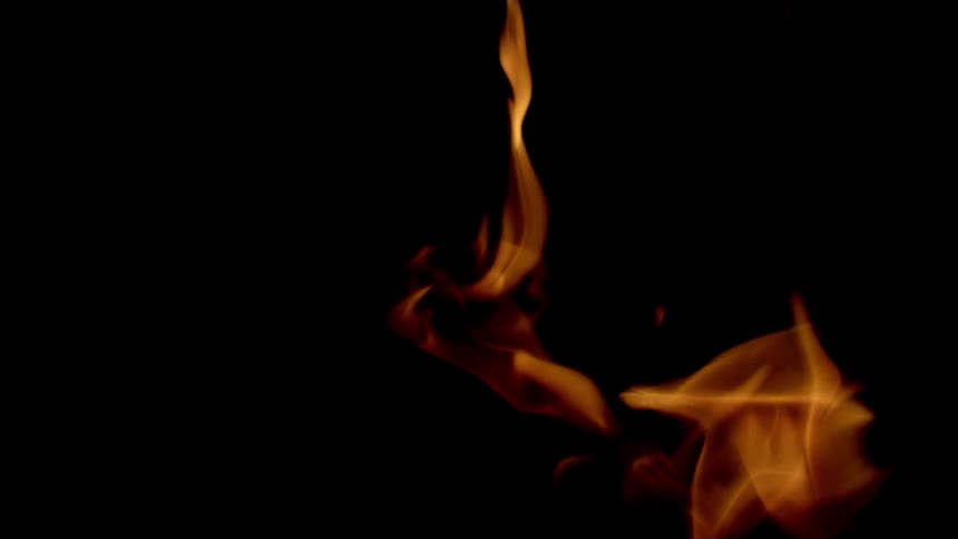 A golden flame of fire fading into a black background