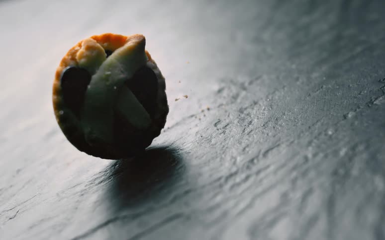 A small pie falling onto a reflected stone floor