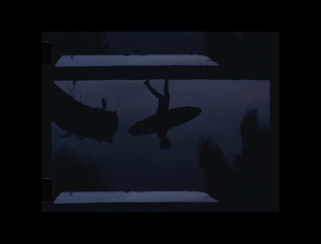 Shadow on a lake of a man with his surfboard walking