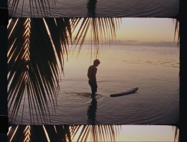A man walking to a board in shallow water one morning