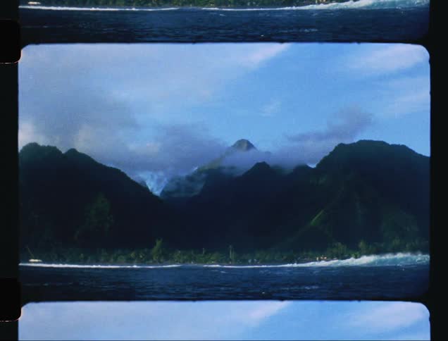 Waves crash along the coast near mountains
