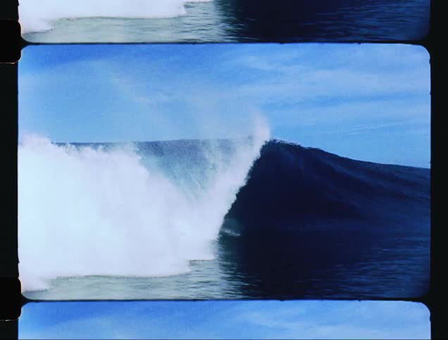 Surfer rides a surfboard over a large wave