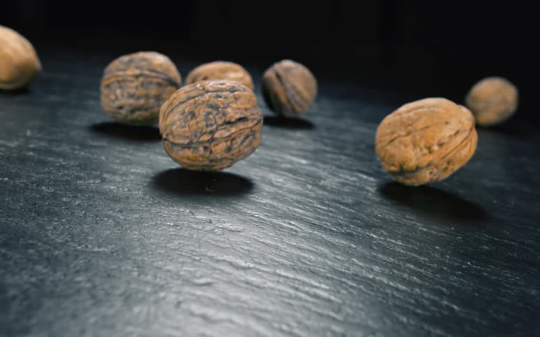 Several nuts rolling on a stone floor