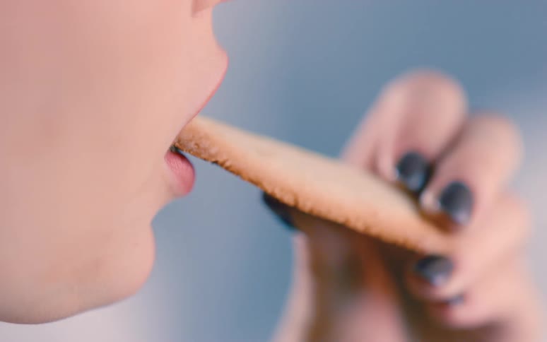 An animation of a female human face eating a cookie