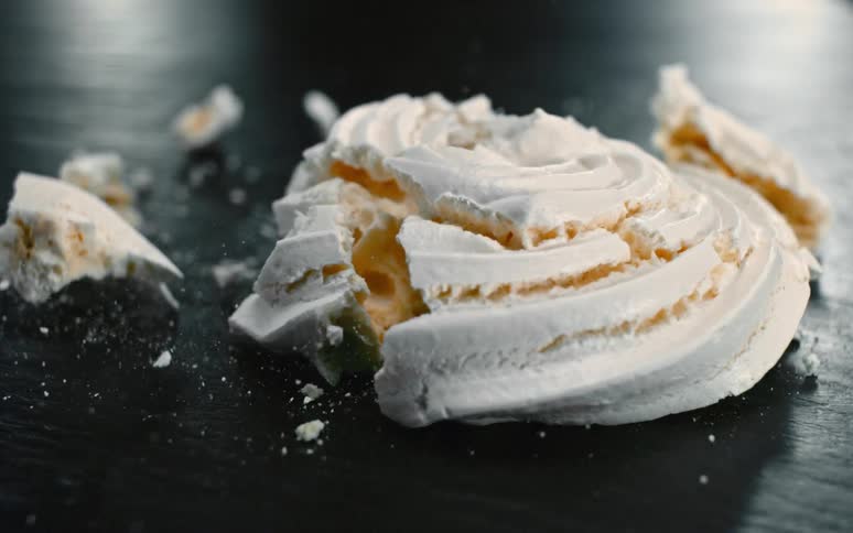 A white dessert falling to the floor and shattering