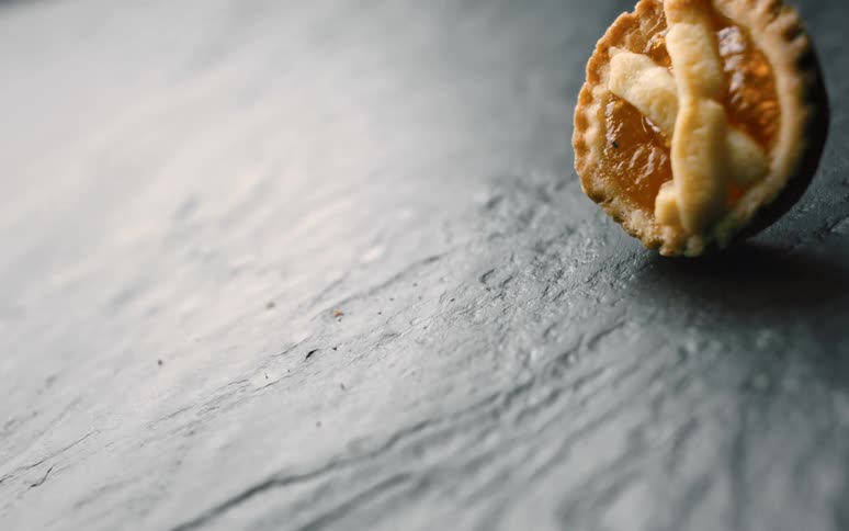 A small pie falling onto a reflected stone floor