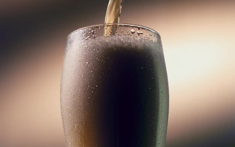 Beverage pouring into a tall glass