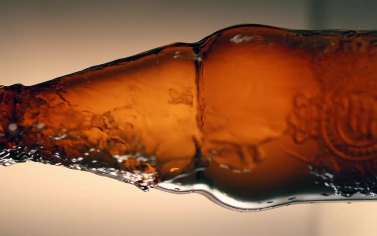 A clear liquid falling from a brown glass bottle