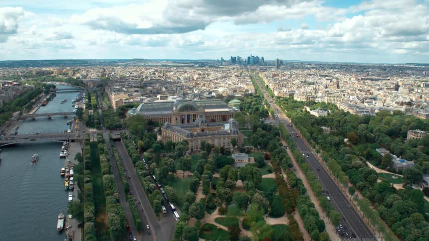Landmark building with extensive grounds sits between river and highways a long distance from city skyline on cloudy day