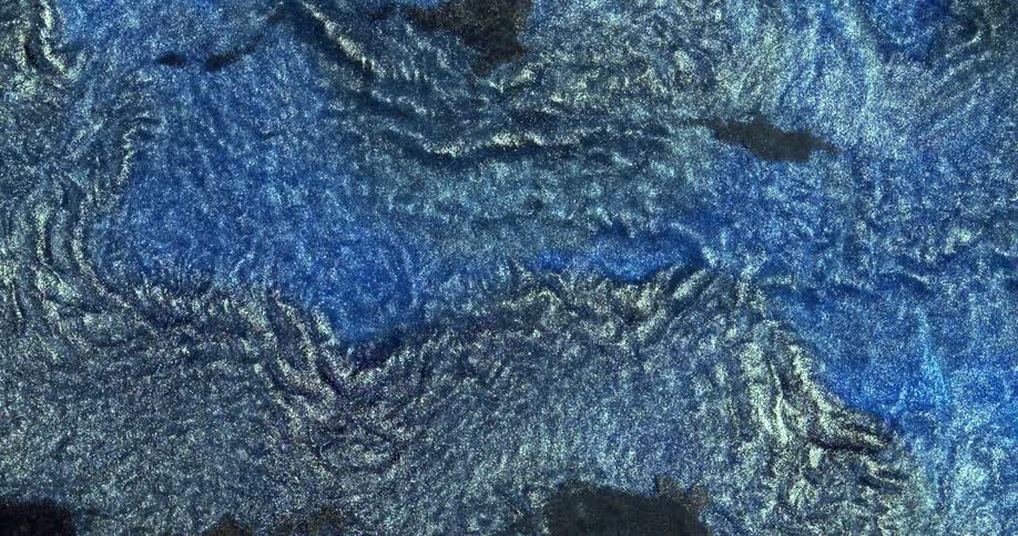 Abstract fluid texture of flowing sparkling metallic glitter