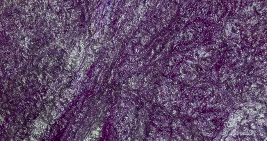 Moving liquid glitter inks creating a wavy metallic abstract background