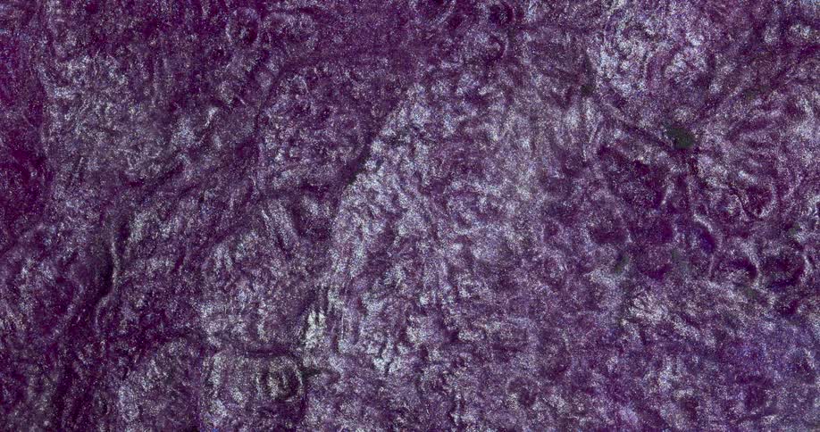Moving liquid glitter inks creating a wavy metallic abstract background