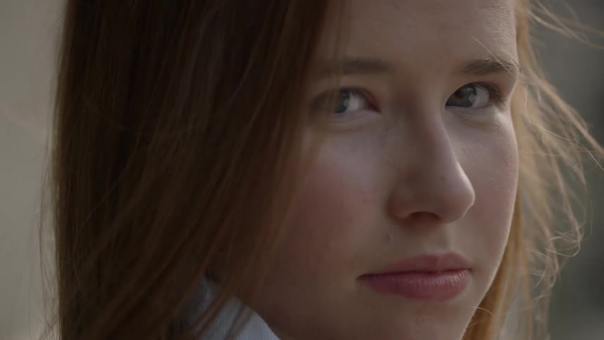 A woman blinks her eyes and looks up