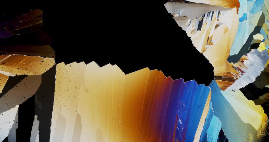 Smoothly growing crystals of liquid chemical watched with microscope