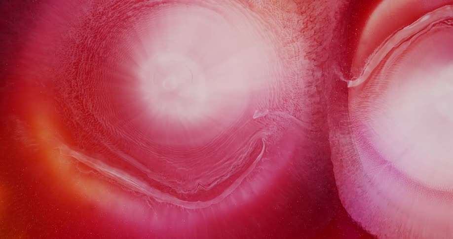 Expanding circles of abstract pearlescent ink drops flowing background
