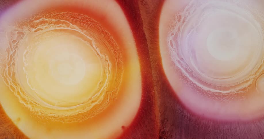 Expanding circles of abstract pearlescent ink drops flowing background