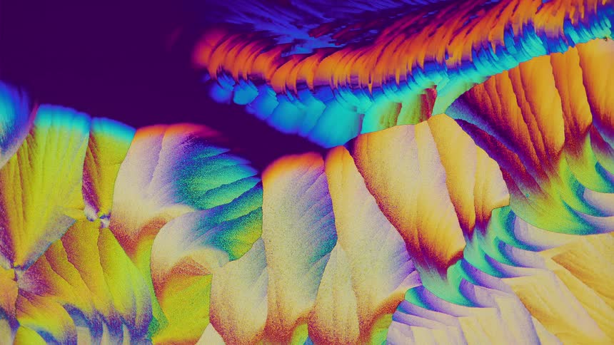 Colorful crystals growing and forming abstract shapes under microscope