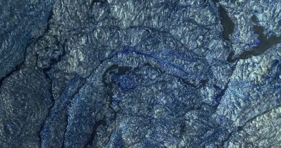 Abstract fluid texture of flowing sparkling metallic glitter