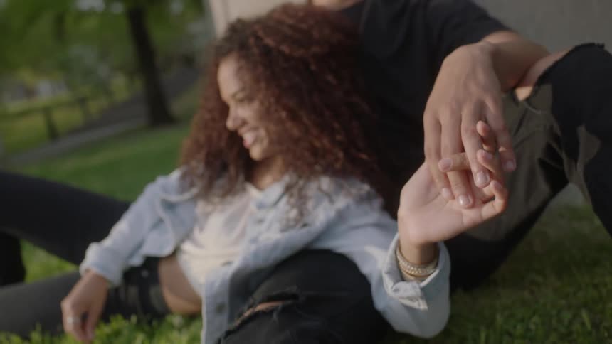 A woman is laying on a seated man's lap