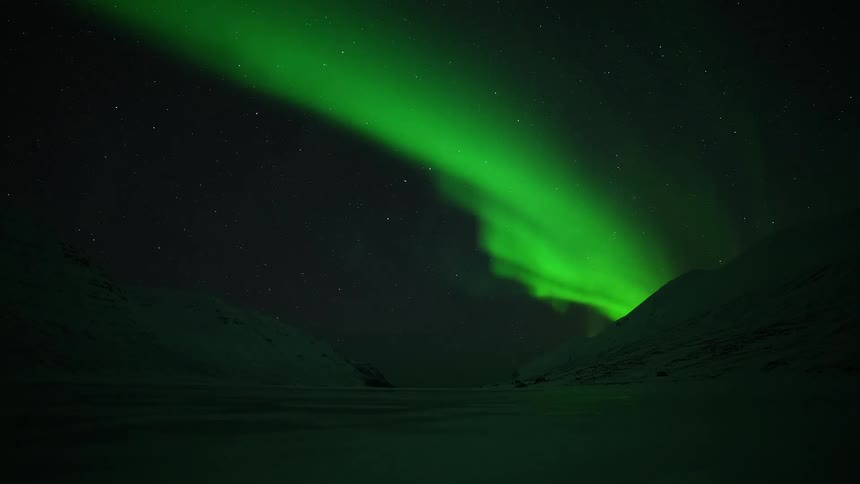 Beams of green light in the sky due to the northern lights in the arctic