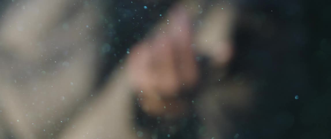 A person blowing a shiny powder out of their hand