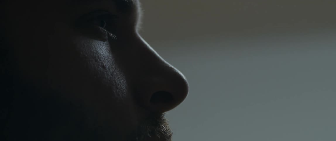 A mans face with a beard where his skin has points of illumination from a light source
