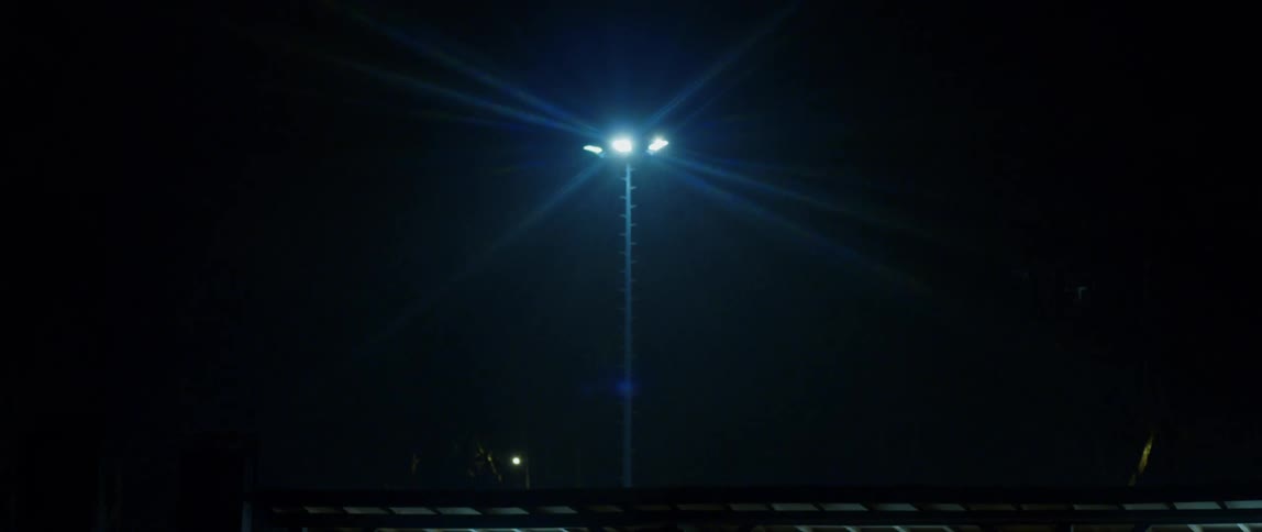 A lamppost with a bright light and a flare of light