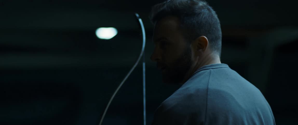 A bearded man holding a bow