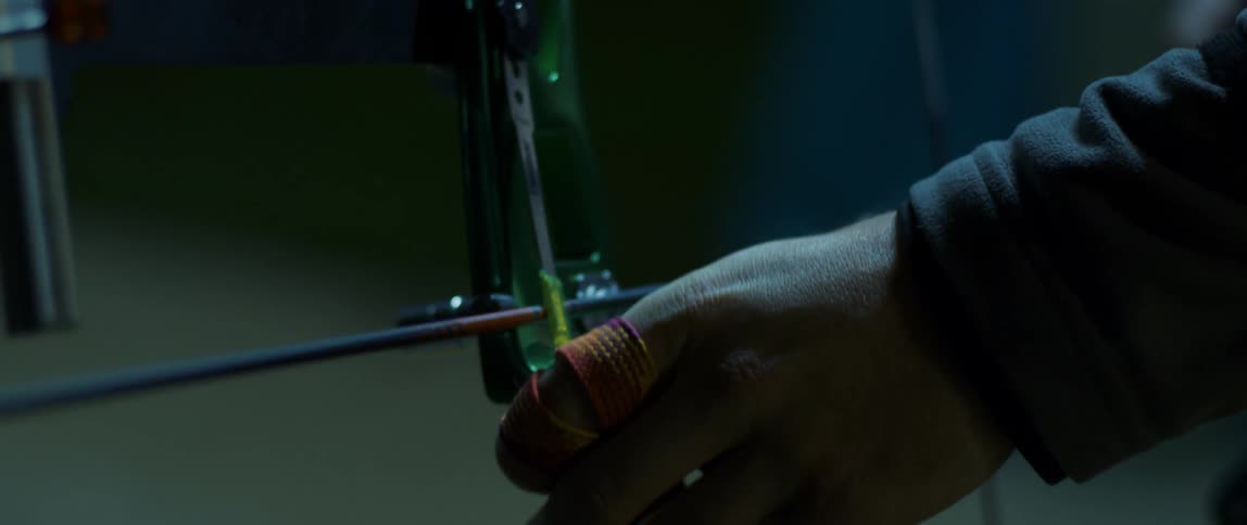 A mans hands are shown putting an arrow onto a bow