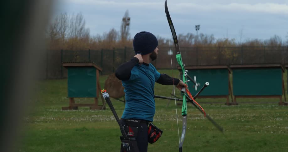 Man shooting an arrow with his bow in an open field