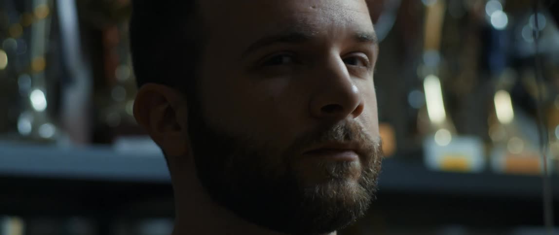 A man looks into the distance and then turns his head to the camera