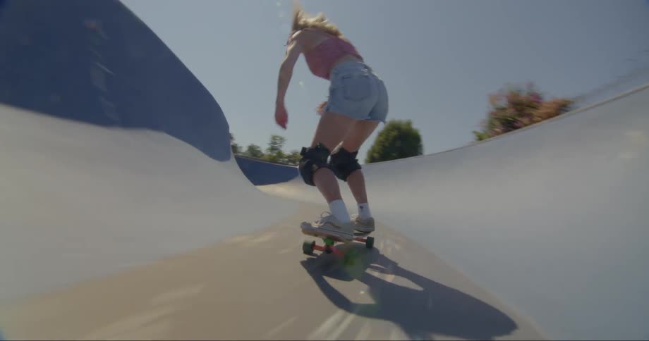 A blonde woman skateboarding on a rink