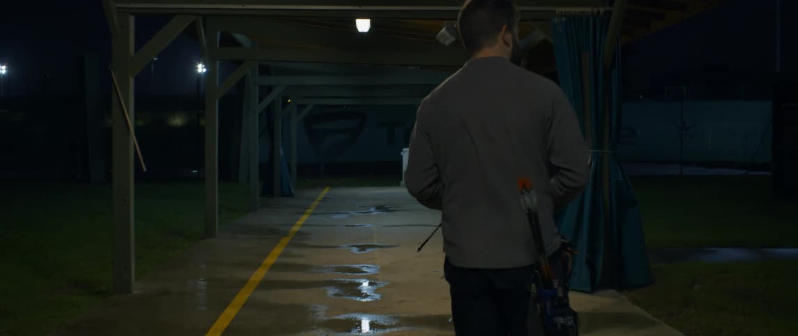 A man walking on a path covered with puddles of water on the ground