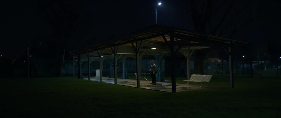 A man standing at a shooting range one night