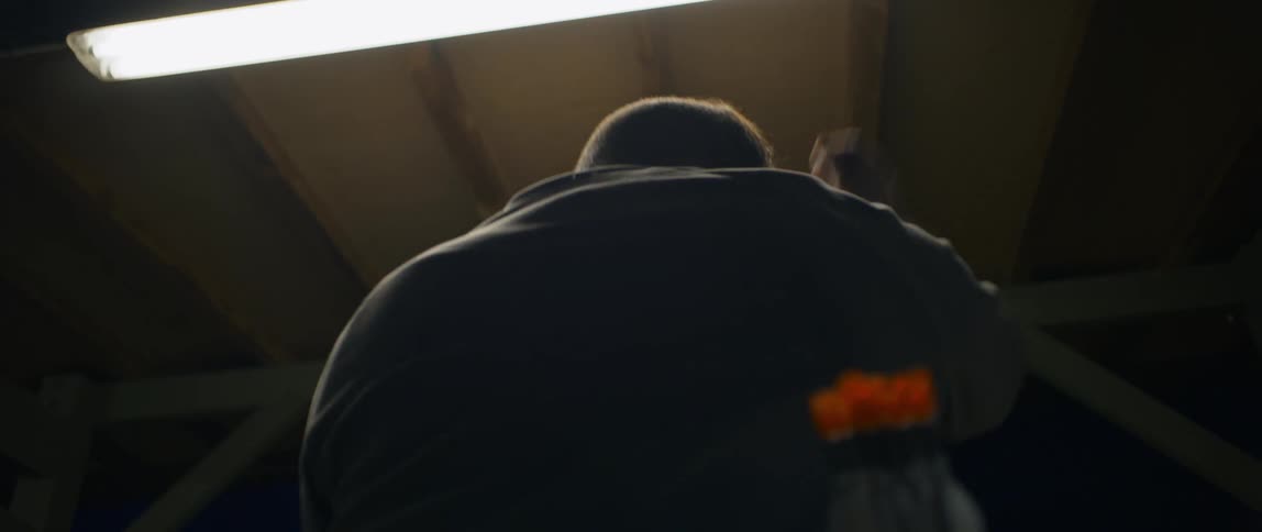 A man shown from behind flails his arms around
