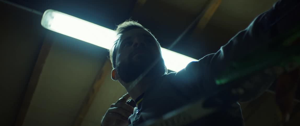 A man with a beard pulling the bowstring and shooting