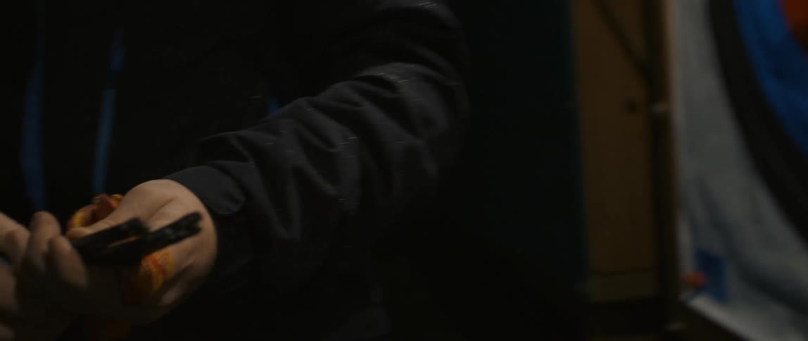 A man removing an arrow from a training target with his right hand