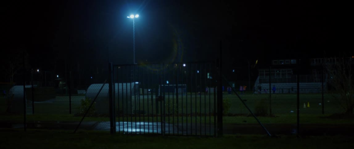 A sports field is shown at night under a streetlight