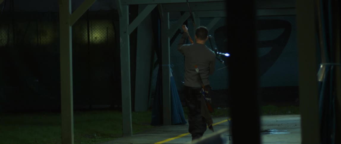 Man walking and picking up a bow and arrow