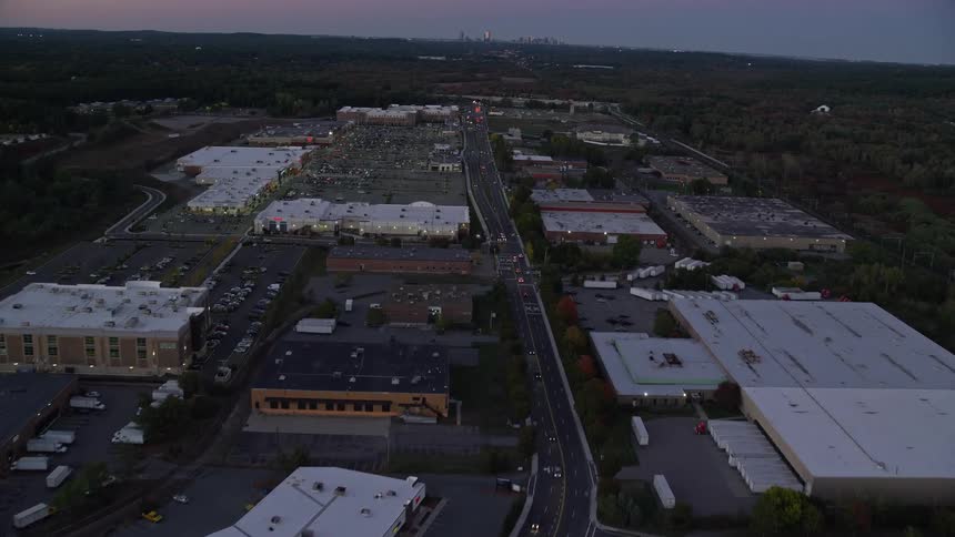 An aerial of a shopping center and distribution warehouse at dusk