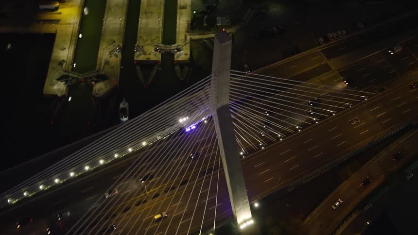 Aerial of moving cars on a bridge in a metropolis at night