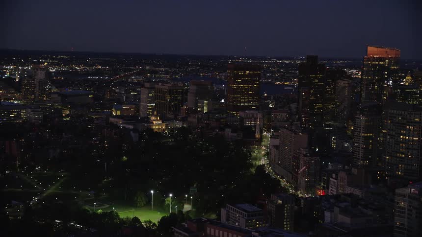 A city with huge buildings on a night with apartments that the lights are on