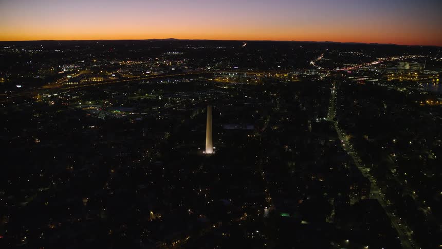 Aerial view of a city at night with a reddish sky