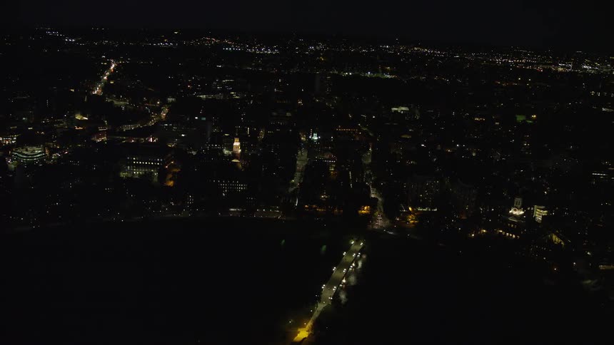 Aerial view of a metropolis by the sea at night