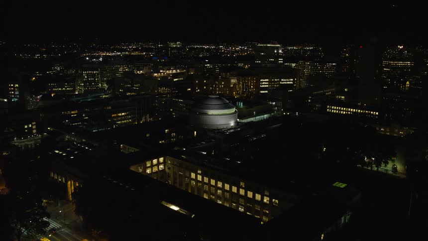 Aerial of buildings and roads with moving cars in a metropolis at night