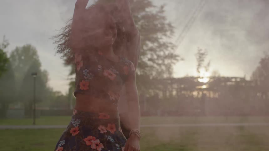 A man and woman are dancing with pink dust covering them