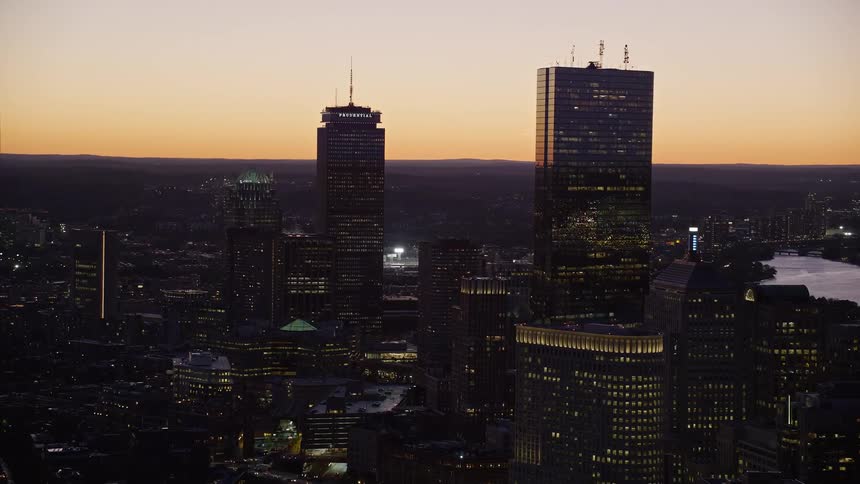 A morning with an orange sky in a city with huge buildings