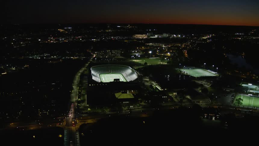 Aerial nighttime view of a stadium in the midst of the city