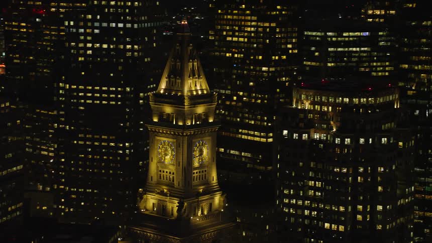 An aerial of a clock tower in an urban area at night