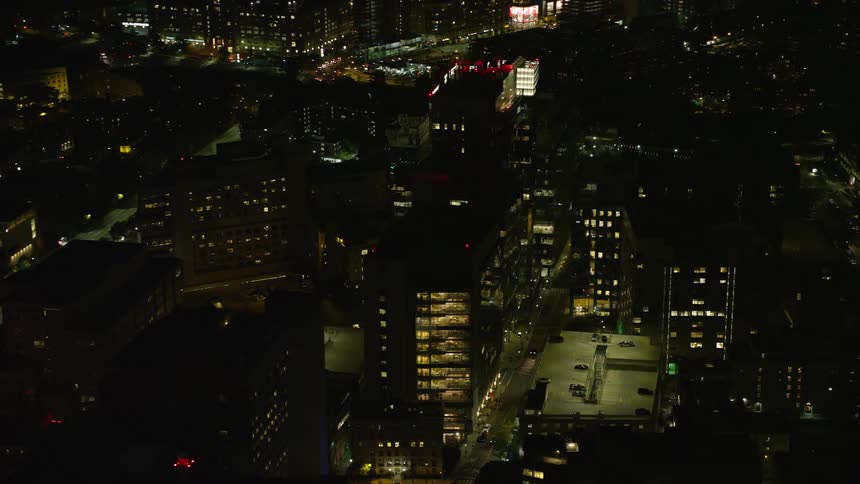 Several buildings in a city with lights on one night